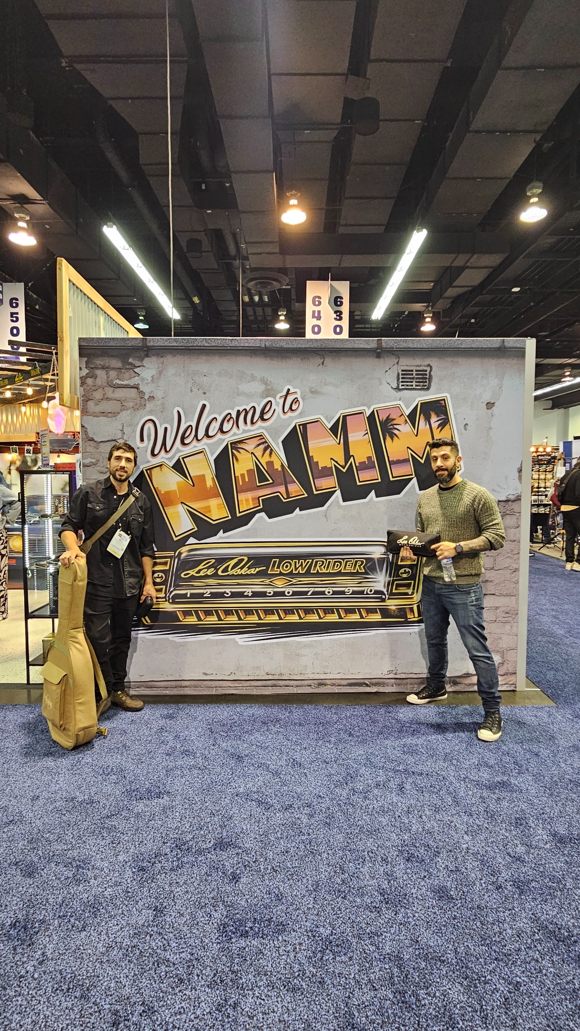 Nicolás Rivas and a fellow musician at the Lee Oskar LowRider display at NAMM 2026